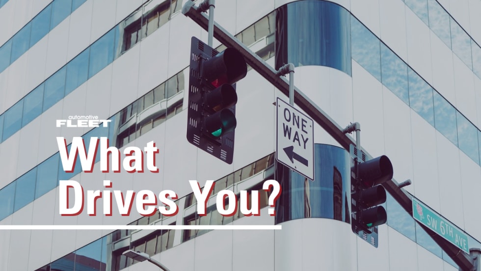 Image of a building and stop lights with text reading, "What Drives You?"