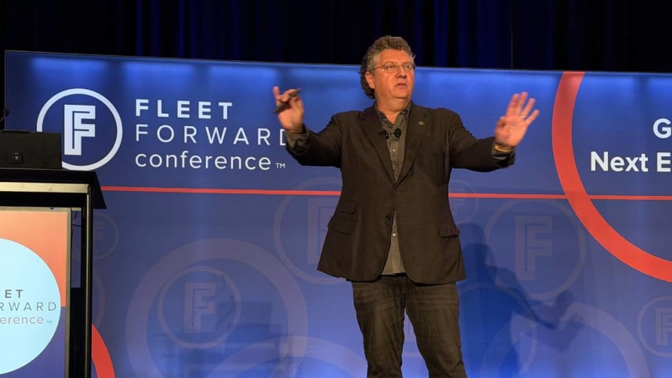 Speaker Bill Sims on the FFC stage with both hands up, emphasizing a point during his safety keynote address.