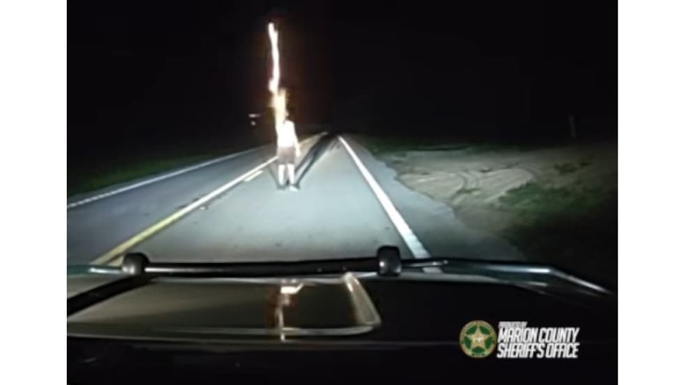 Nighttime dashboard view of police vehicle dashcam with road ahead