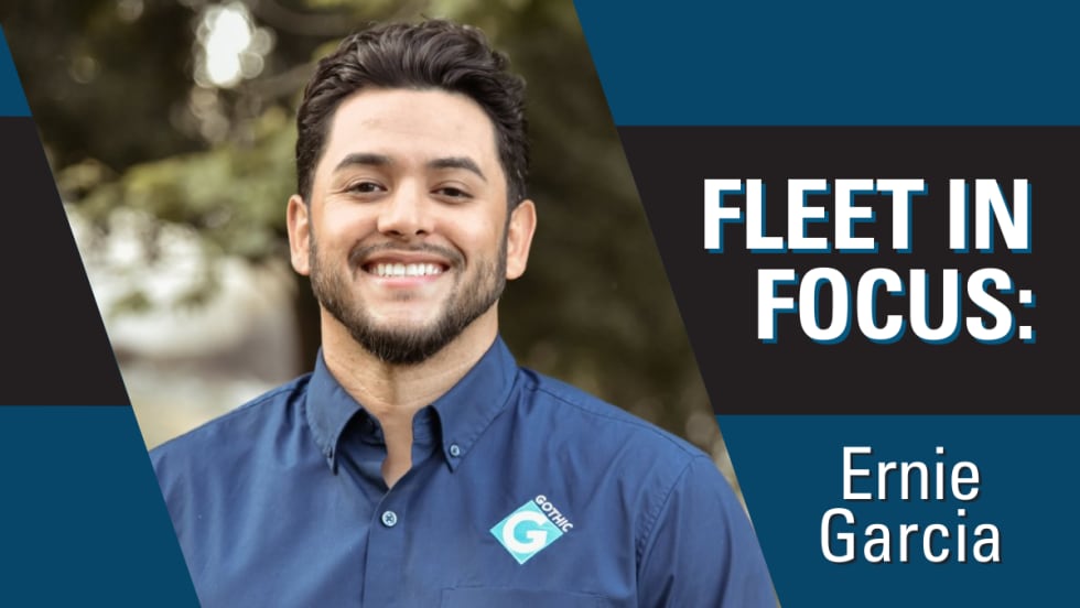 A man poses outside for a business portrait with a Gothic Landscape collared shit. The words "Fleet in Focus" are on the top right.