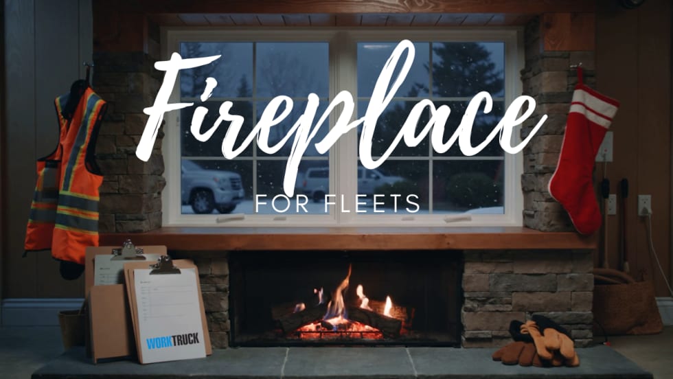 Fleet-themed fireplace with safety vest, clipboards, work gloves, and a crackling fire, designed to bring holiday warmth to fleet offices and maintenance shops.