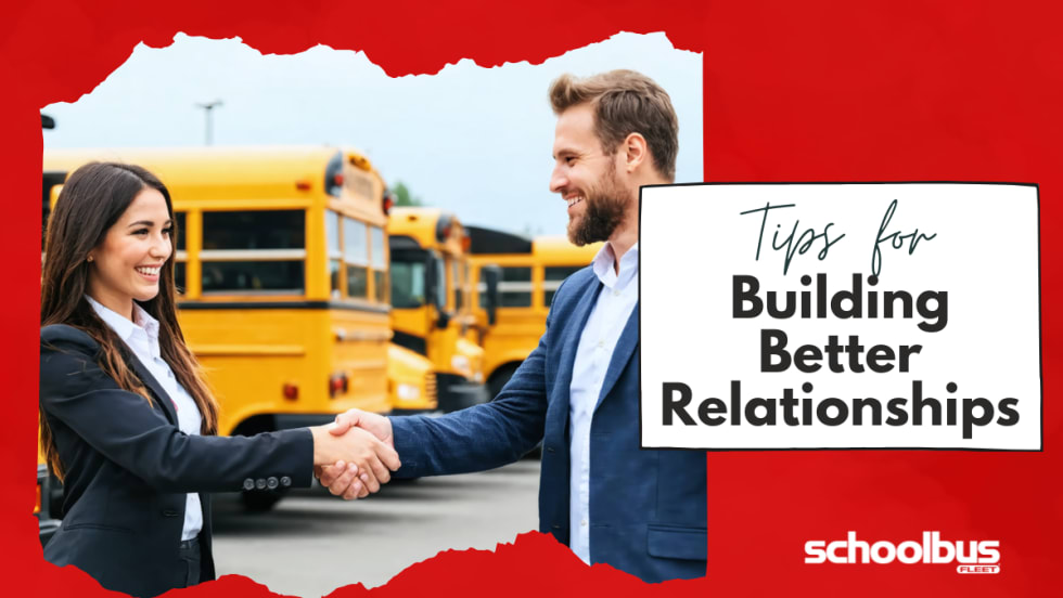  An image of a woman and a man, both dressed in professional attire, shaking hands in a school bus dealership lot surrounded by various buses.