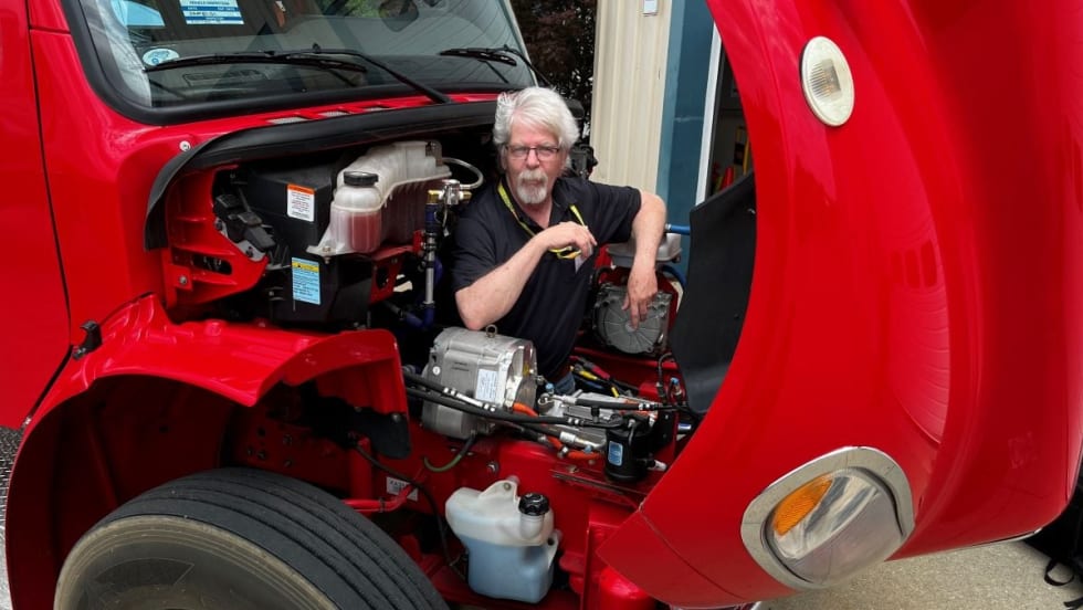 HDT equipment editor Jim Park in the engine bay of a Freightliner truck.