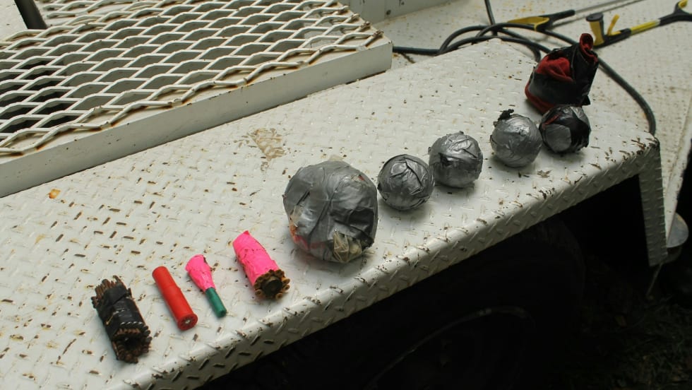 Assorted metal objects, electrical components, and colored tubes on industrial surface