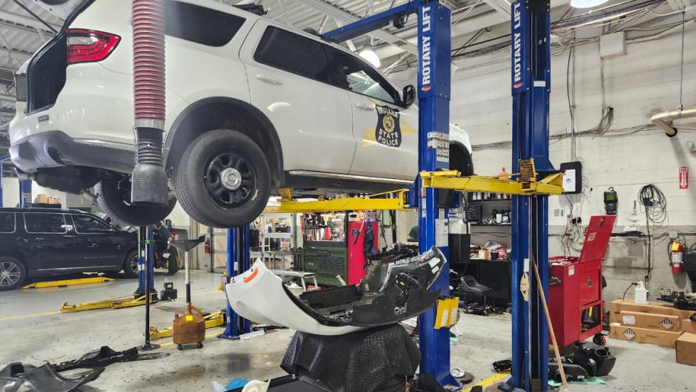 A white Dodge Durango Pursuit is pictured on a blue Rotary lift.