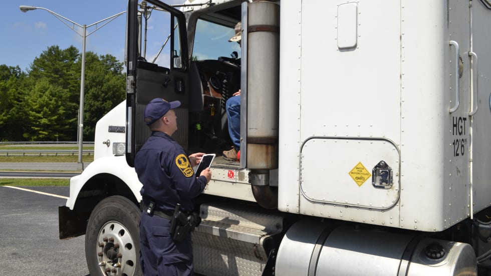  Truck with door open and enforcement officer talking to driver about ELD
