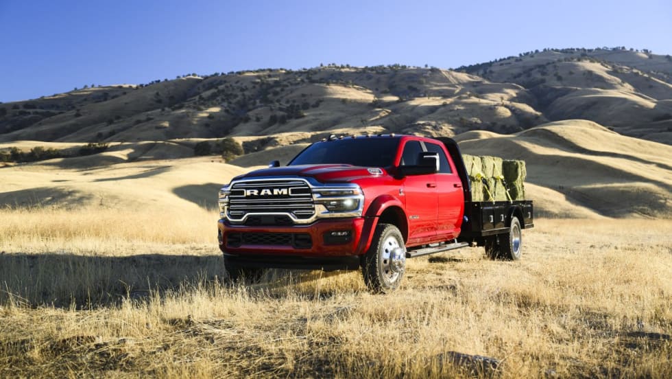 A red 2025 Ram Chassis Cab in a yellow grass field with hills in the background.