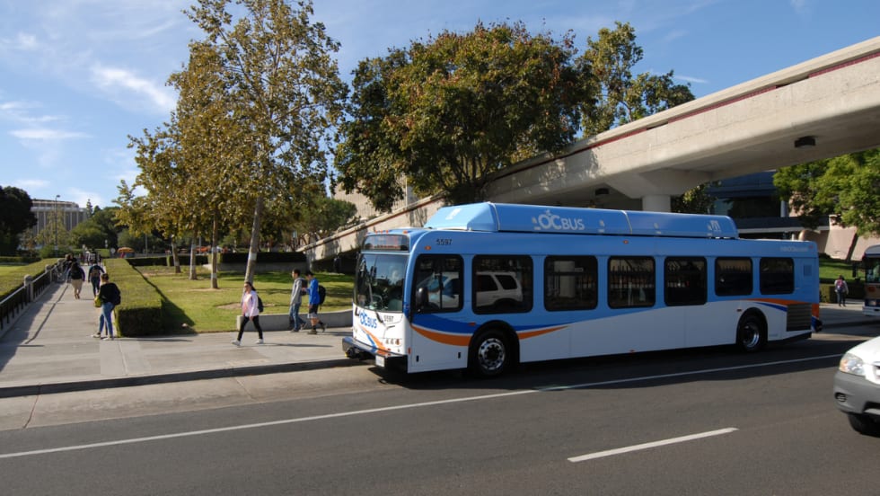 A blue OCTA transit bus at a bus stop.