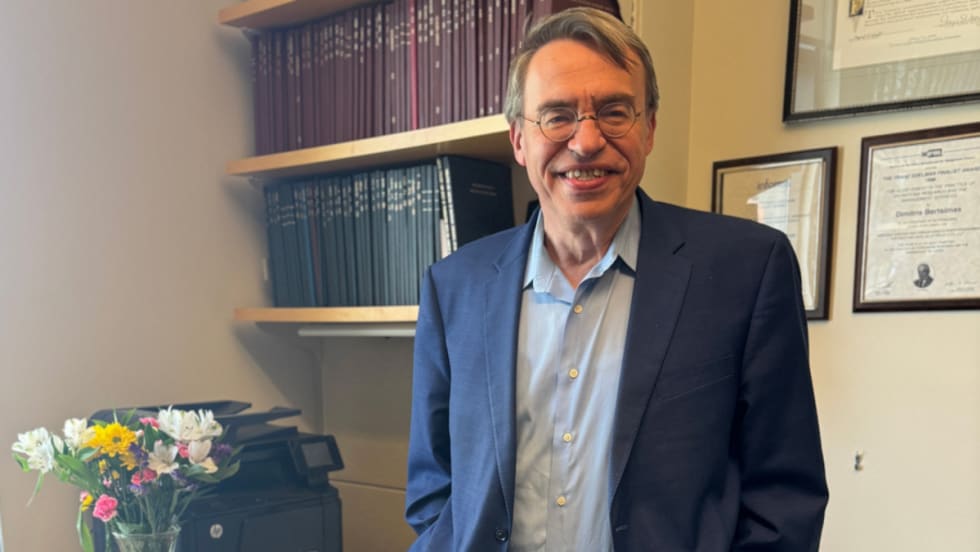 Dimitris Bertsimas poses for a picture in an office.