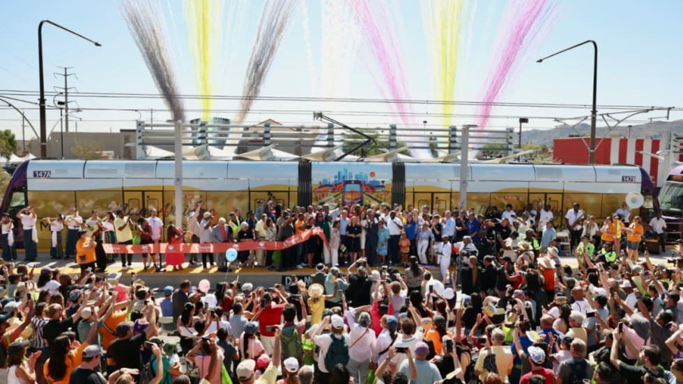 A community ribbon-cutting ceremony with fire works in the background.