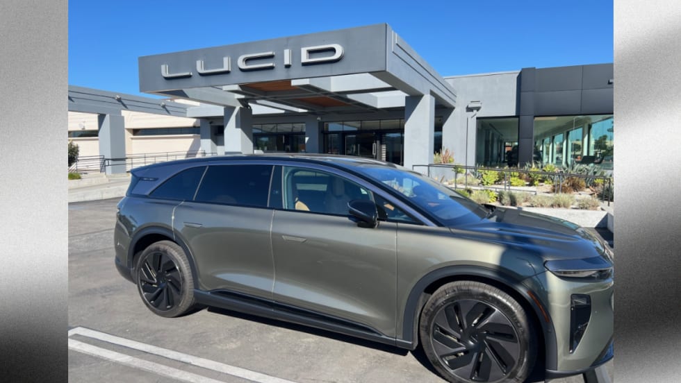 Lucid Gravity electric SUV parked outside a Lucid dealership, highlighting the company’s expanding EV lineup and plans for a new midsize platform and future mobility technologies.