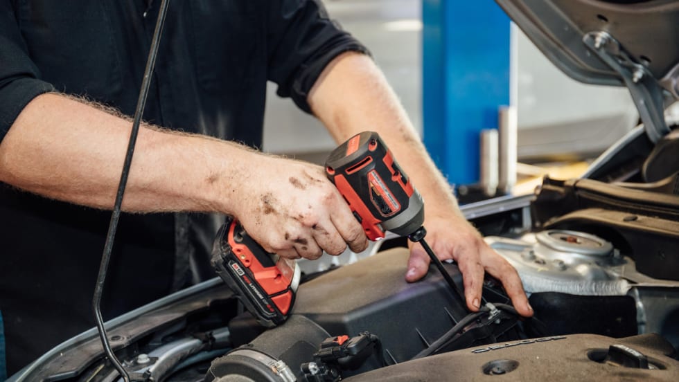 A technician working on a car engine.
