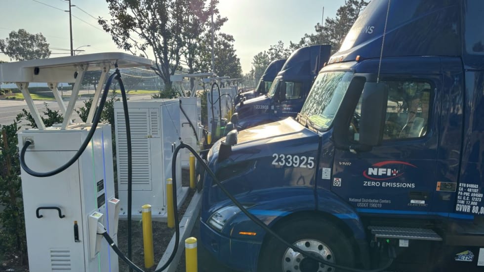 NFI blue electric trucks at charging stations