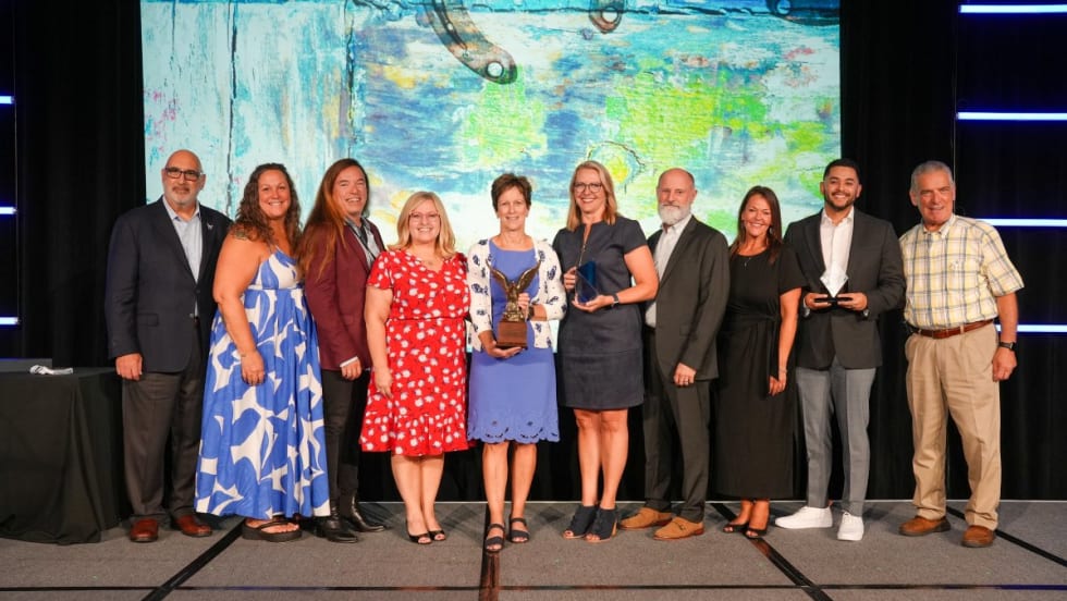 A group of past and present Fleet Managers of the Year and other award recipients pose on stage at the AFLA corporate fleet conference in San Antonio with the newest award winners.