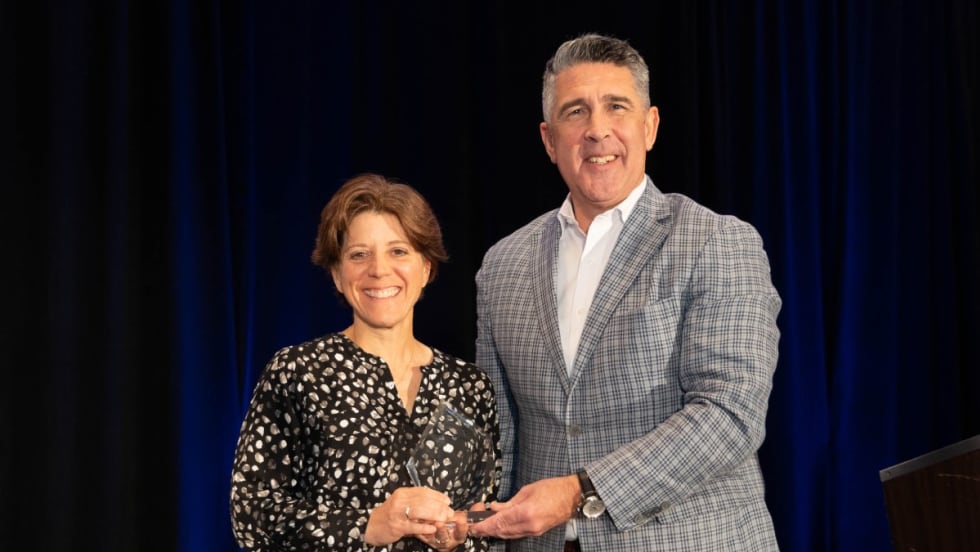 Sandra Doucetter (left) and Mike Joyce (right) post on stage with the 2024 Fleet Safety Award.