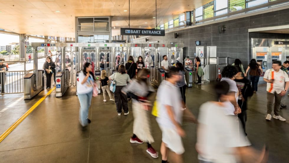 Riders pass through a BART entrance.