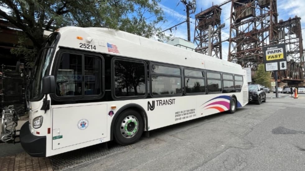 A white NJ Transit bus on a street.