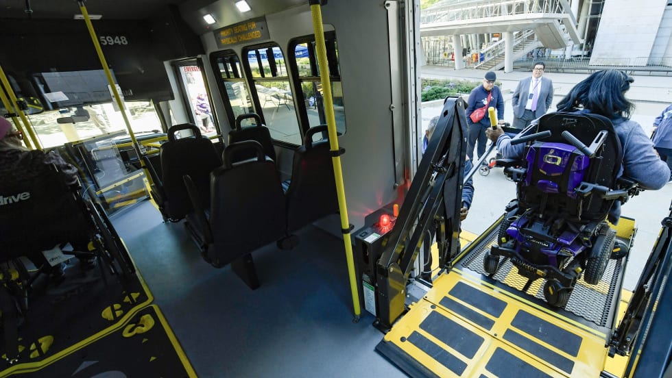 NYTC passenger entering paratransit bus.
