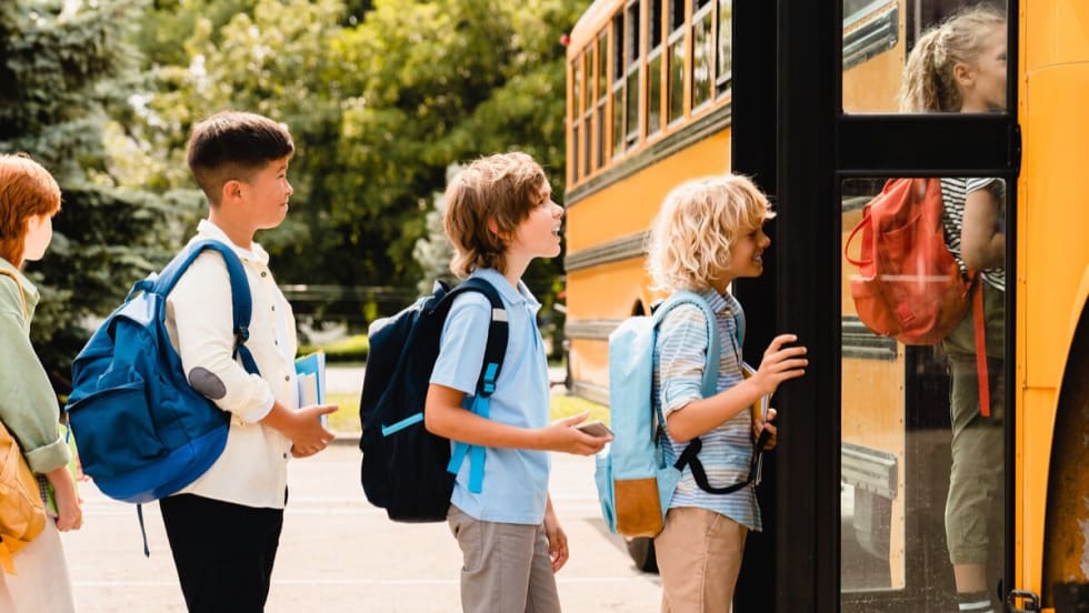 Five students board a school bus.