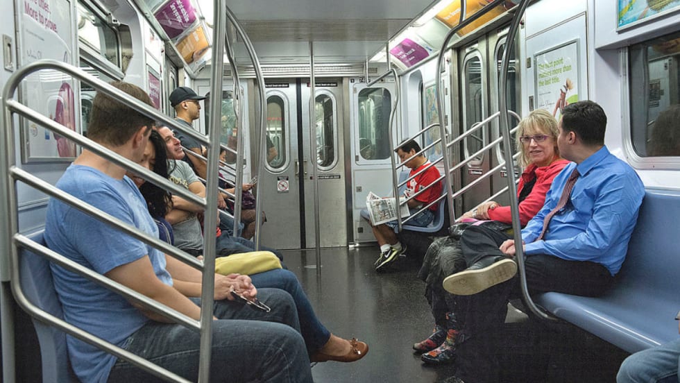 Passengers sitting inside a subway car.
