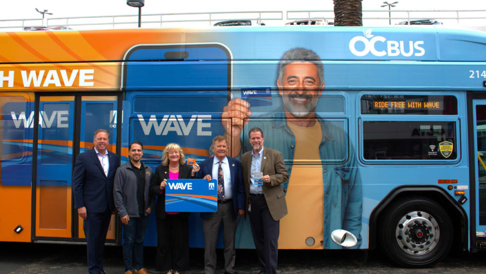 OCTA Board Members and staff pose in front of an OCTA bus.