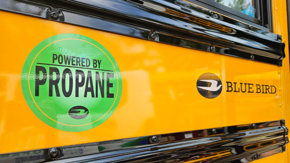 An up-close side image of a Blue Bird with a green graphic that says "Power By Propane."