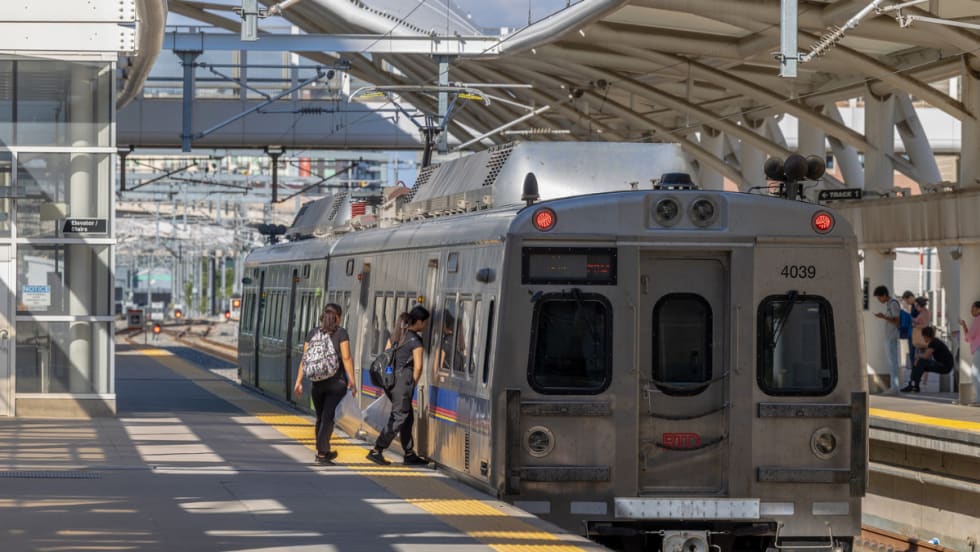 Passengers at a station boarding an RTD train. 