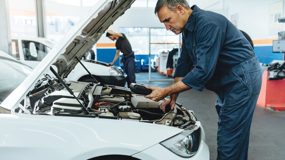 A man working on the engine of a car.