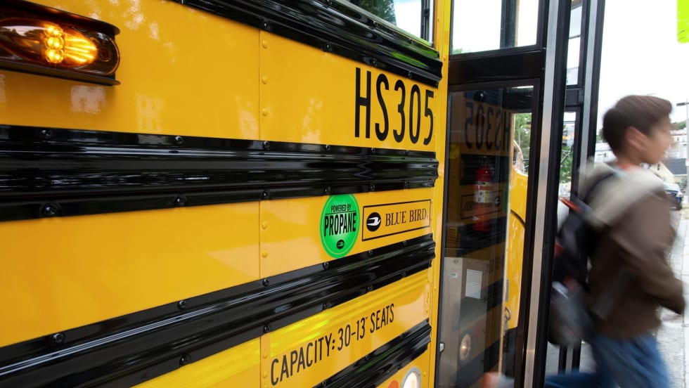 a boy deboards a propane school bus