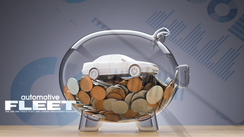 Photo of toy car in glass piggy bank.