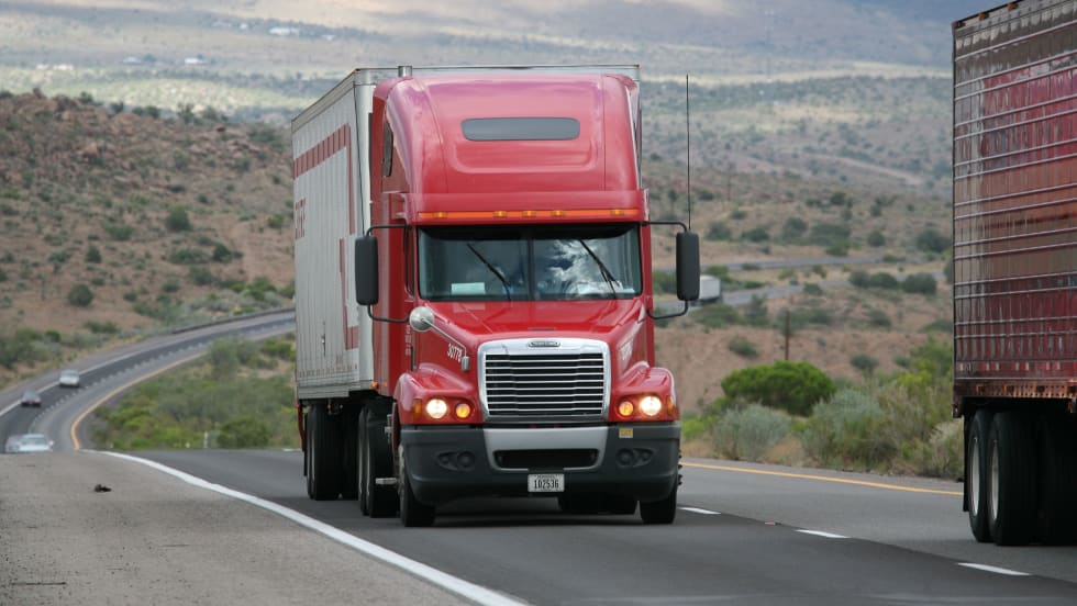 photo of tractor-trailers moving on a rural U.S. highway