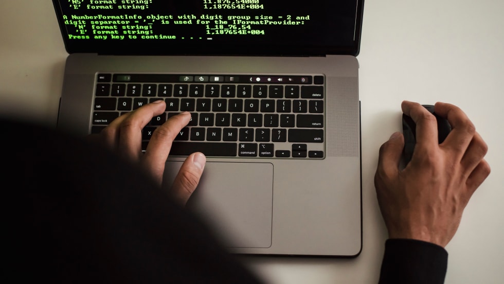 Person at laptop with green-colored code on the screen