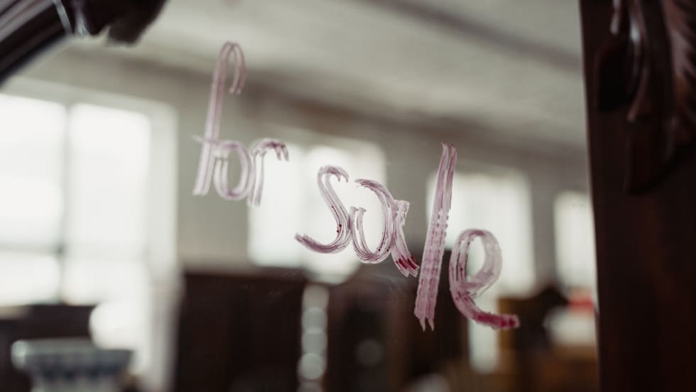 'for sale' written on a building window