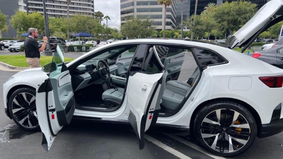  A white Polestar 3 with all doors and trunk lid open while on display at an EV sales event.