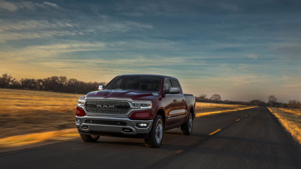 A maroon Ram 1500 Limited drives down a highway.