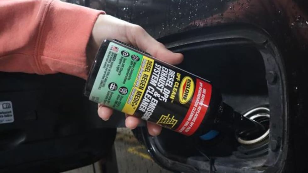 Rislone DPF Cleaner being poured into a fuel tank.
