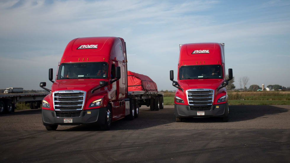 Two red heavy-duty Class 8 trucks with Roehl branding