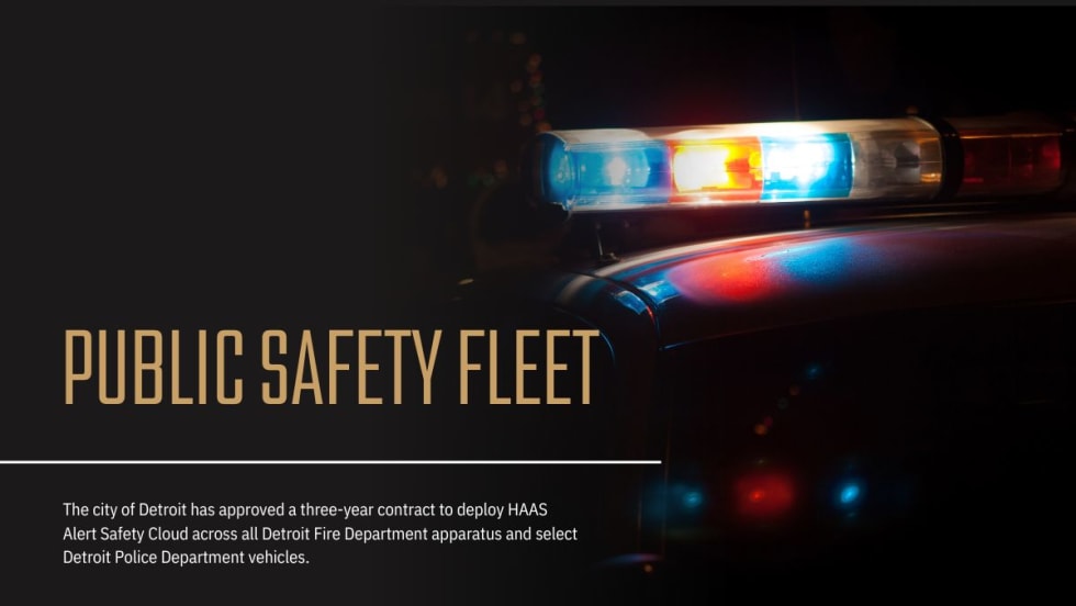 Detroit official speaks at podium with city seal, alongside police and fire leaders, with Detroit Fire vehicles in the background during Safety Cloud announcement.