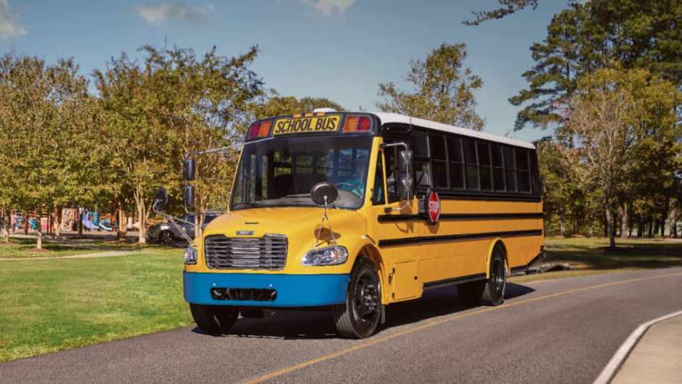 an electric school bus sits on the road