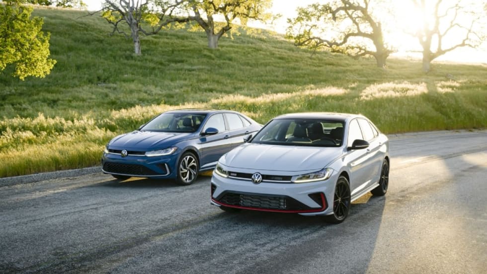 A powder blue 2025 Volkswagen Jetta and a white 2025 Jetta GLI parked on a road.