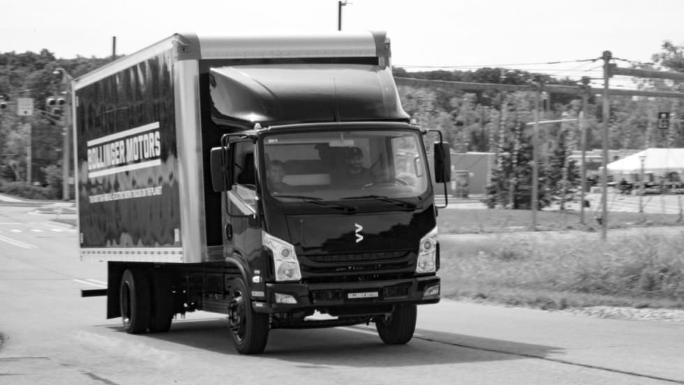 A black and white image of Bollinger B4 EV truck driving on a road.