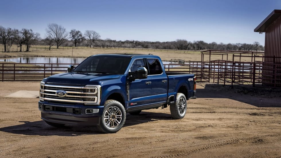 A 2025 Ford F-350 Platinum Plus in Antimatter Blue parked on farm land.