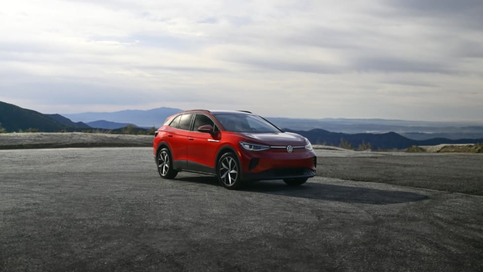 A red Volkswagen ID.4 with mountains on the horizon.