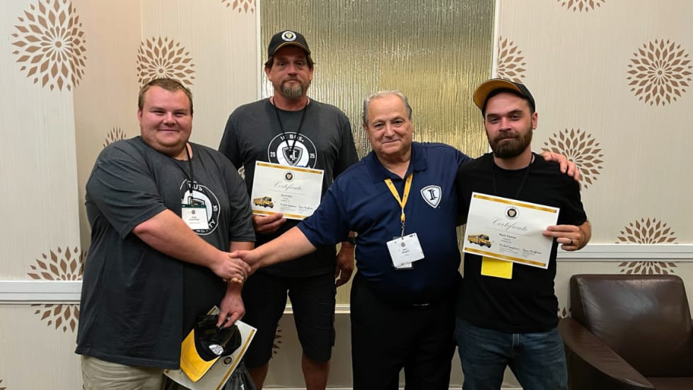 Team members at IC Bus Training with their training completion certificates.