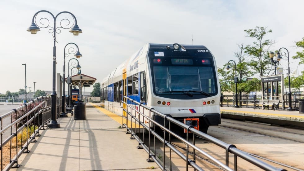 An NJ TRANSIT River LINE rail vehicle at a station.