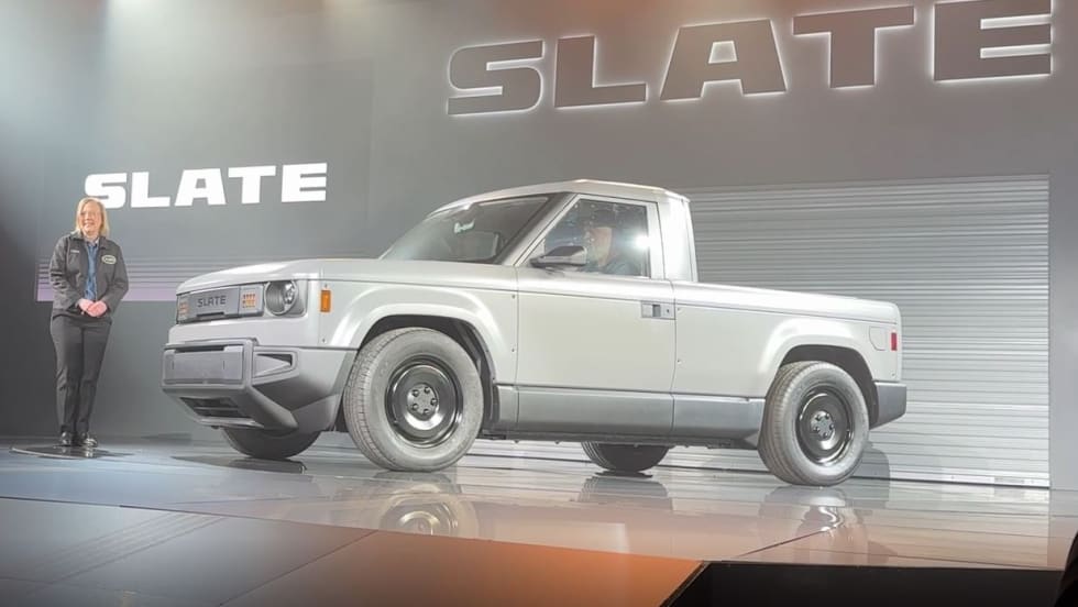Woman on stage at product launch introducing electric truck. 