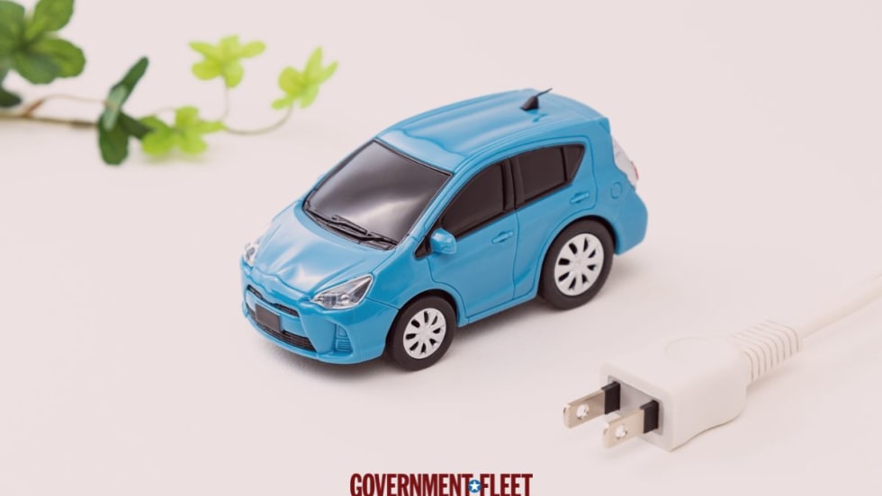 Small blue car with a green leaf and an electric plug.