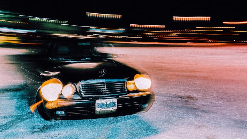 A black blurry car is driving, representing a speeding driver.