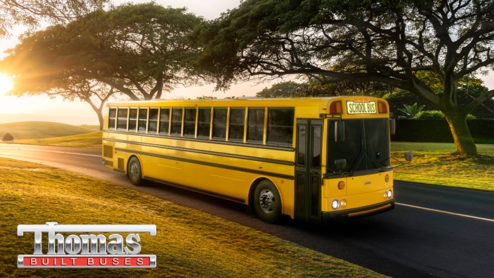 A yellow Thomas Built HDX2 type D school bus is seen driving down the road.