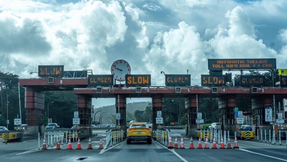 A toll plaza beneath partly sunny cumulonimbus clouds.